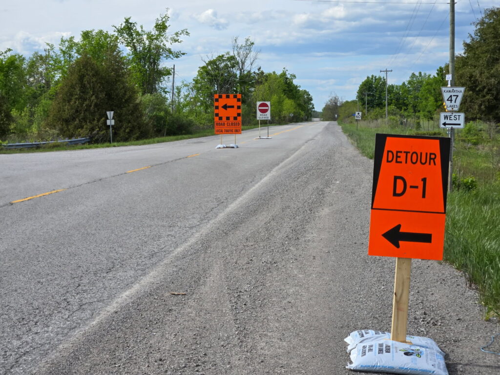 Road with detour and closure signs